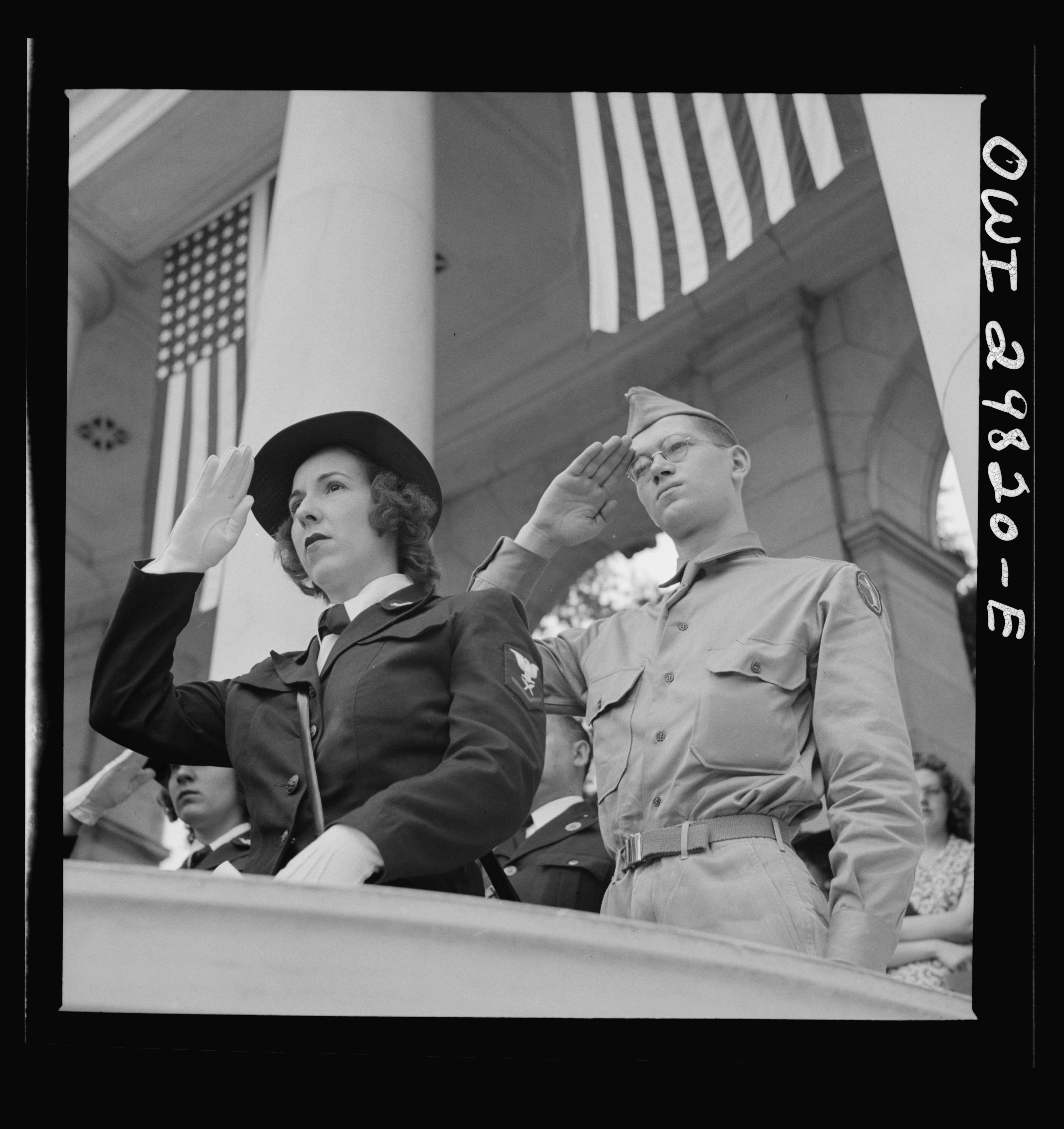 A woman serving in the Navy WAVES and a soldier give a salute