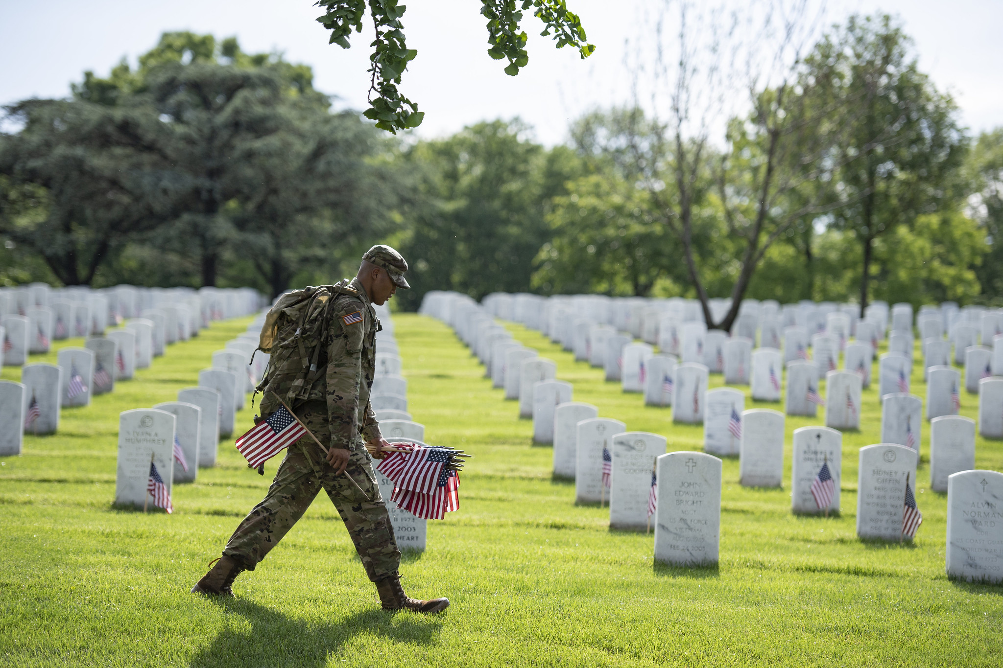 flagsin2637068463663675486 A soldier from the U.S. Army's 3rd Infantry Regiment places flags in front of gravestones for Memorial Day